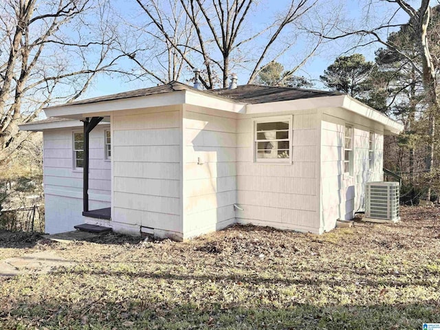 view of property exterior with roof with shingles and central AC unit