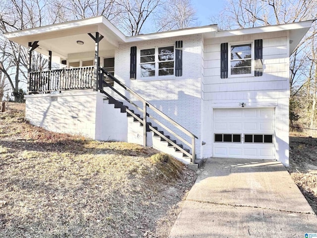 ranch-style home with concrete driveway, an attached garage, stairs, a porch, and brick siding