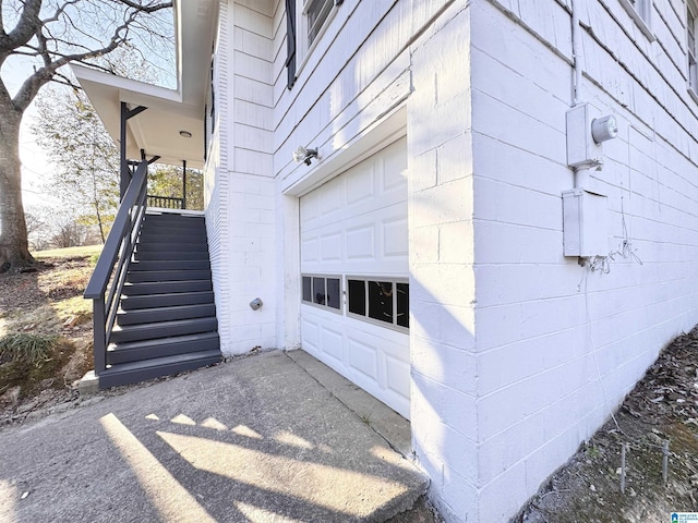 property entrance with a garage and concrete block siding