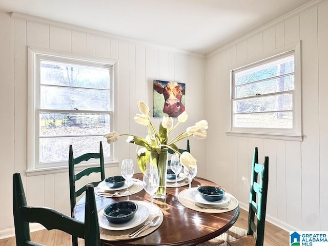 dining room with crown molding, baseboards, and wood finished floors