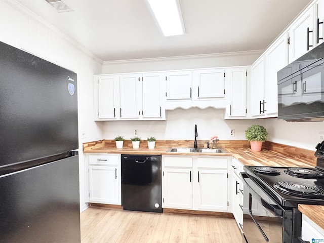 kitchen featuring black appliances, ornamental molding, a sink, and white cabinetry