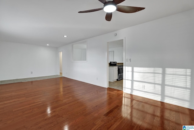 empty room with light wood finished floors, a ceiling fan, and recessed lighting