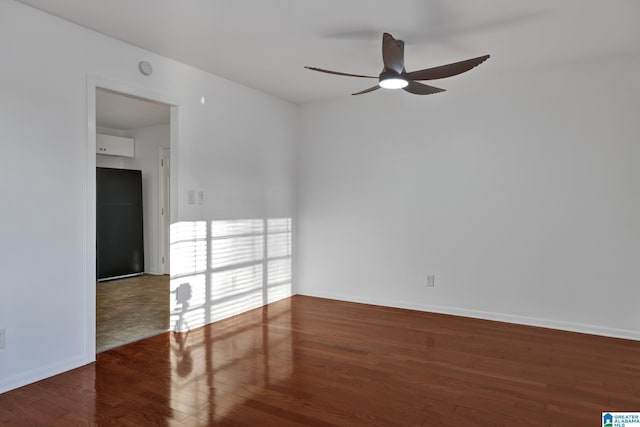 unfurnished room featuring a ceiling fan, baseboards, and wood finished floors