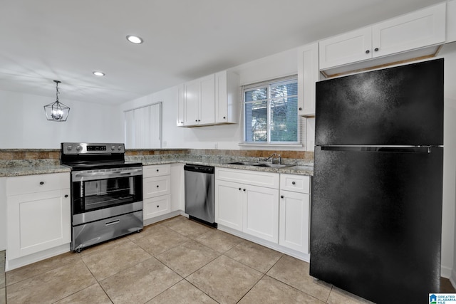 kitchen with appliances with stainless steel finishes, a sink, light stone counters, and white cabinets