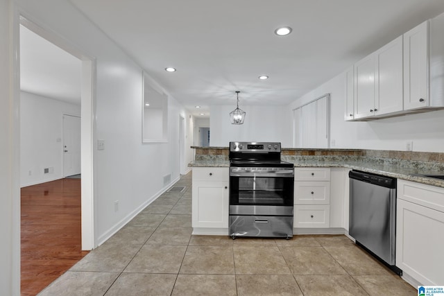 kitchen with a peninsula, appliances with stainless steel finishes, and white cabinetry