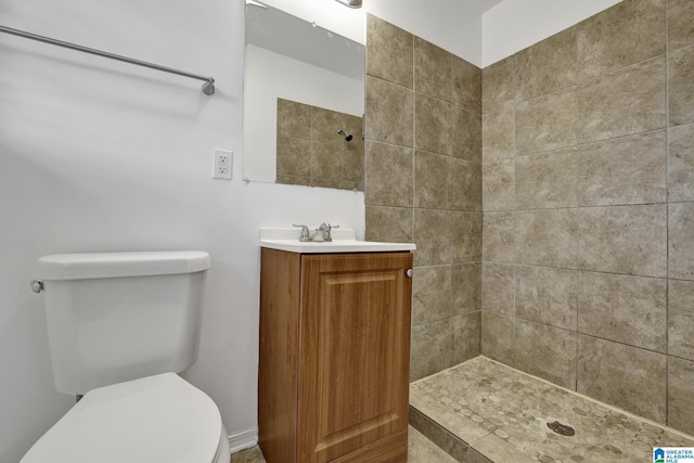 bathroom featuring tiled shower, vanity, and toilet