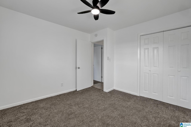 unfurnished bedroom with a closet, dark carpet, a ceiling fan, and baseboards