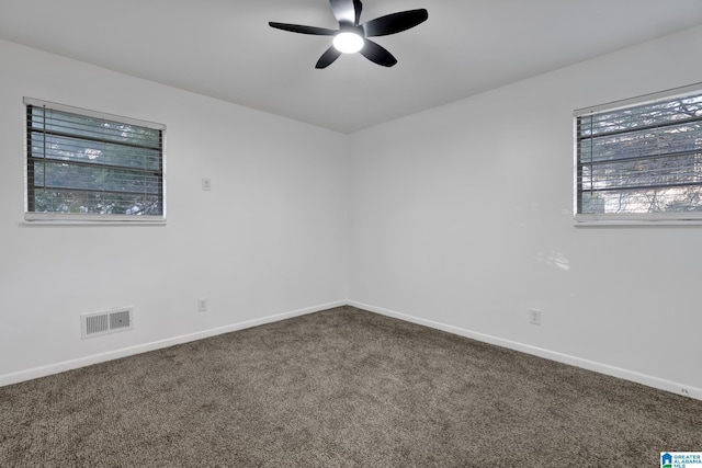 carpeted spare room with visible vents, ceiling fan, and baseboards