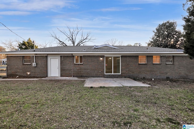 back of property with a patio, a yard, and brick siding