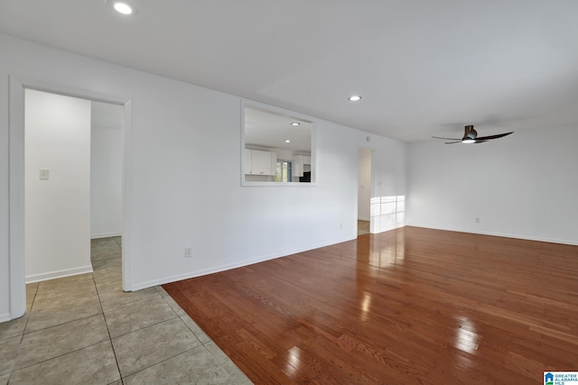 unfurnished living room featuring a ceiling fan, recessed lighting, baseboards, and wood finished floors