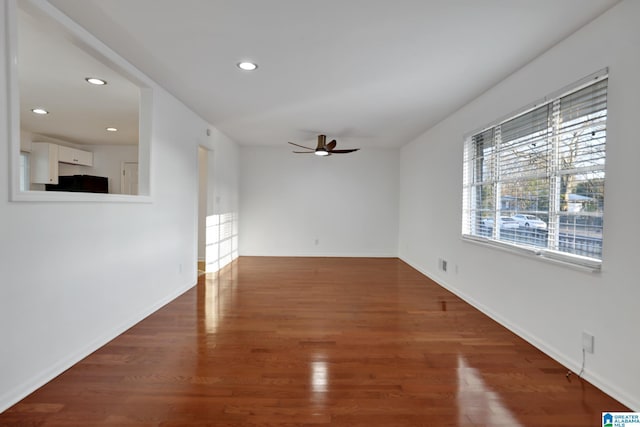 empty room featuring baseboards, wood finished floors, a ceiling fan, and recessed lighting