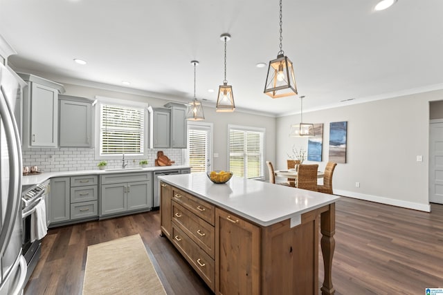 kitchen featuring dark wood-type flooring, light countertops, a sink, and backsplash