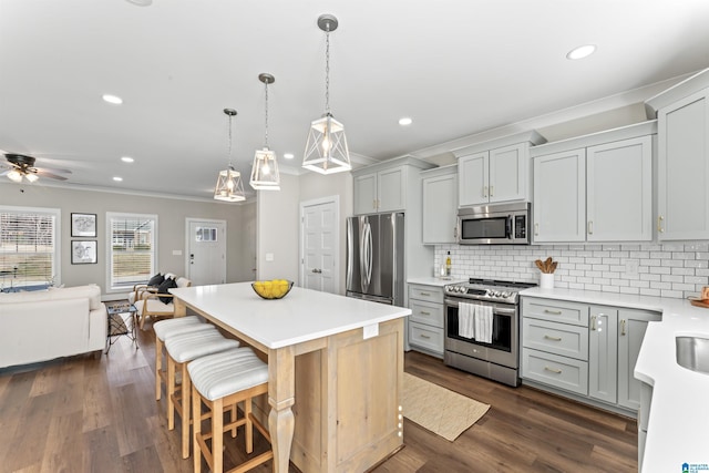 kitchen featuring a center island, stainless steel appliances, light countertops, backsplash, and open floor plan