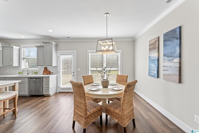 dining room featuring baseboards, dark wood-type flooring, crown molding, and recessed lighting