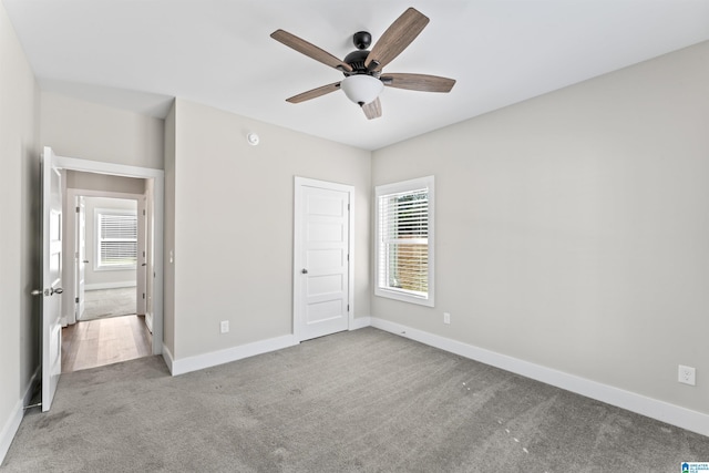 unfurnished bedroom with carpet floors, a closet, ceiling fan, and baseboards