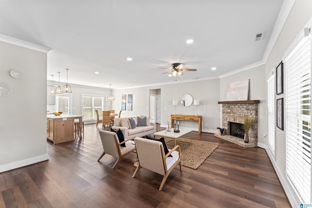 living area featuring a fireplace, visible vents, dark wood-style flooring, and ornamental molding