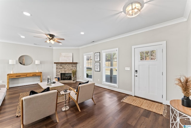 living room featuring baseboards, a brick fireplace, wood finished floors, and crown molding