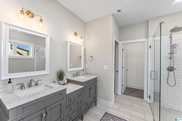 full bathroom with a sink, a shower stall, baseboards, and double vanity