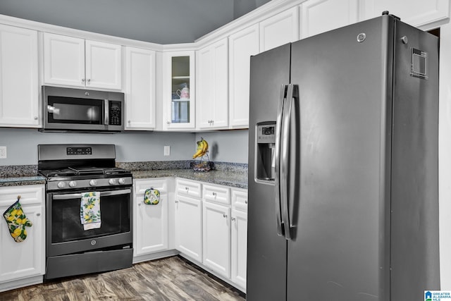 kitchen featuring appliances with stainless steel finishes, dark wood-type flooring, and white cabinets