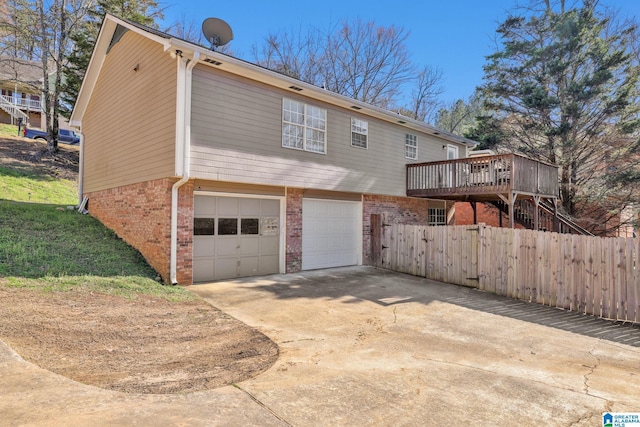 exterior space with an attached garage, brick siding, fence, driveway, and stairway