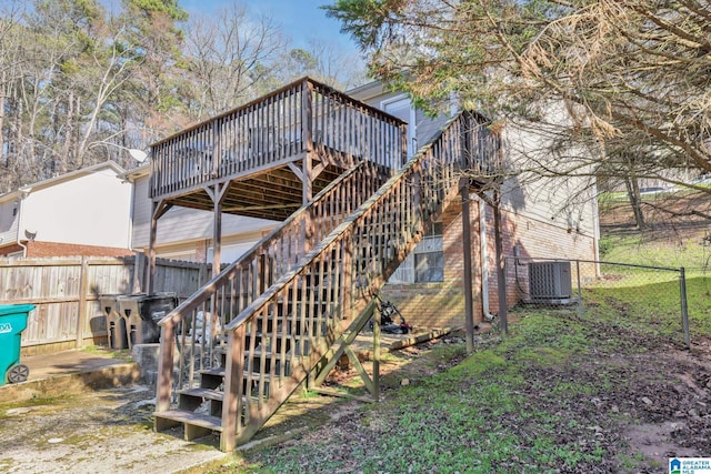 rear view of house with fence private yard, central AC, brick siding, and stairway