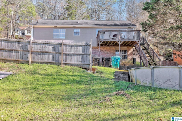 back of property with stairs, a lawn, a wooden deck, and fence