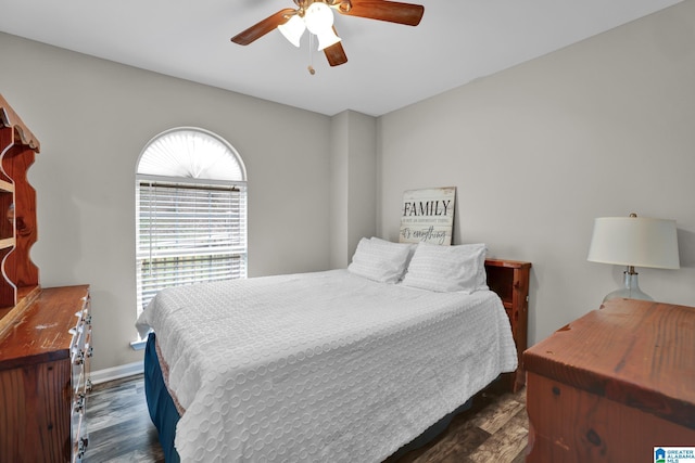 bedroom with dark wood-style floors, ceiling fan, and baseboards