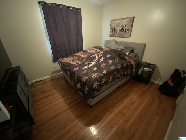 bedroom with wood finished floors and baseboards