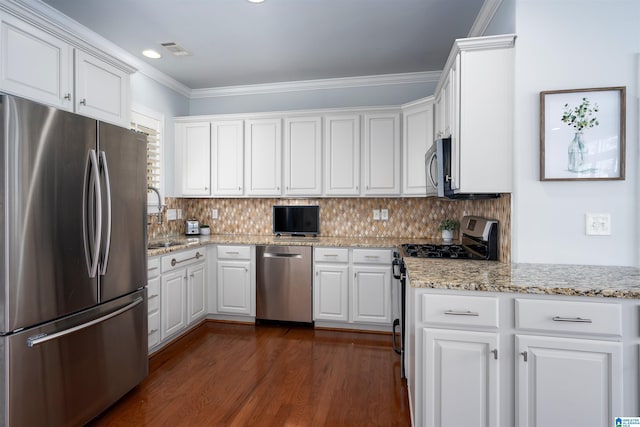 kitchen with appliances with stainless steel finishes, visible vents, ornamental molding, and white cabinetry