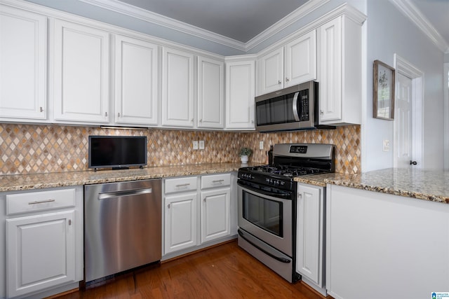 kitchen featuring dark wood finished floors, decorative backsplash, appliances with stainless steel finishes, ornamental molding, and white cabinets