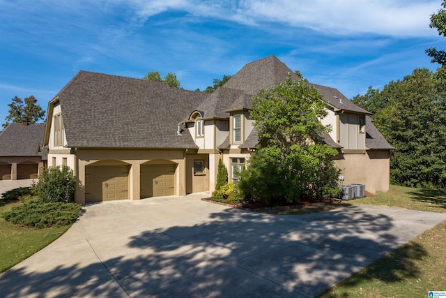 french provincial home featuring a garage, roof with shingles, driveway, and stucco siding