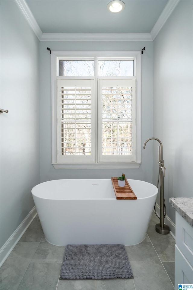 full bathroom featuring a freestanding tub, crown molding, vanity, and baseboards