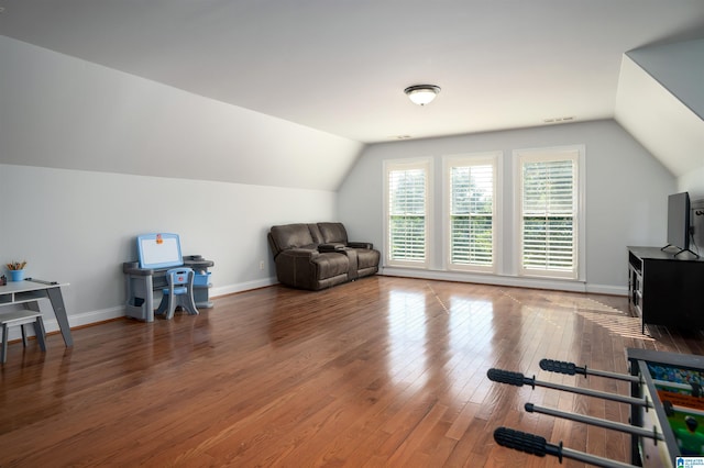 interior space with lofted ceiling, hardwood / wood-style floors, visible vents, and baseboards