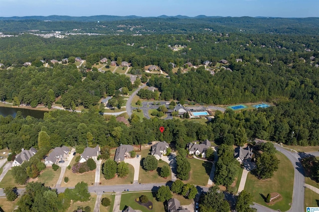 bird's eye view with a wooded view