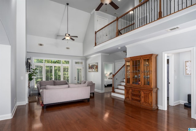 living room featuring a high ceiling, stairway, wood finished floors, and visible vents