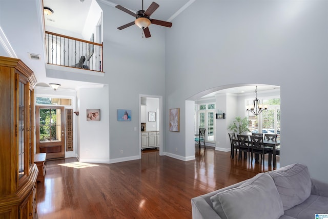 living room with baseboards, wood finished floors, visible vents, and crown molding