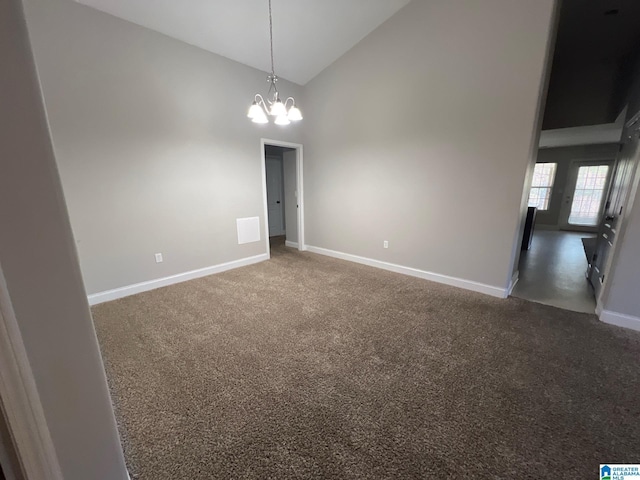 carpeted spare room featuring high vaulted ceiling, baseboards, and a notable chandelier