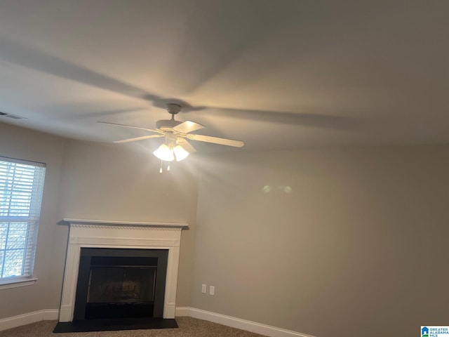 room details with visible vents, baseboards, a ceiling fan, a fireplace with flush hearth, and carpet