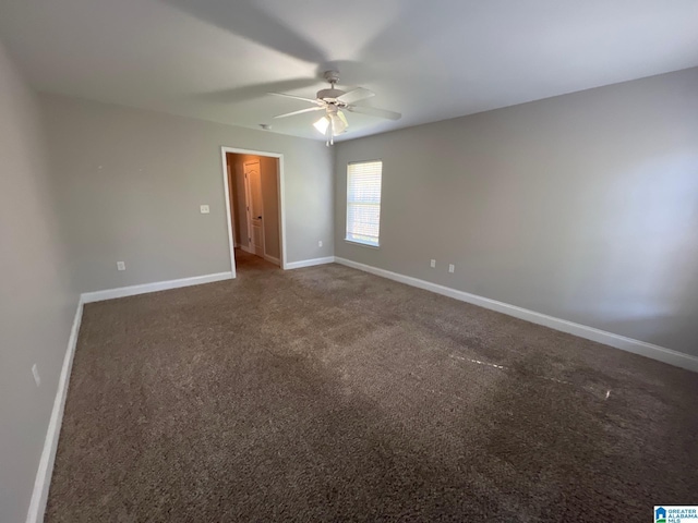 carpeted empty room featuring a ceiling fan and baseboards