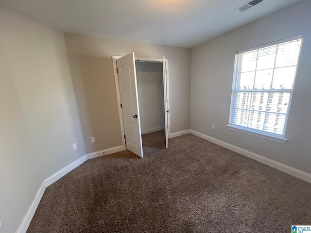 unfurnished bedroom featuring carpet flooring, visible vents, and baseboards