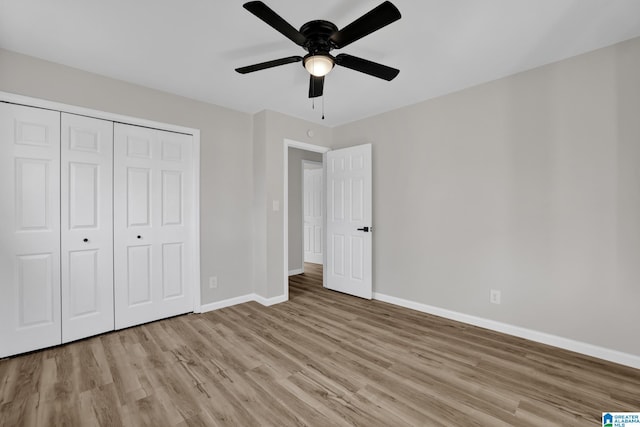 unfurnished bedroom featuring a closet, wood finished floors, a ceiling fan, and baseboards