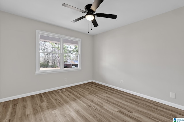 spare room with ceiling fan, wood finished floors, and baseboards