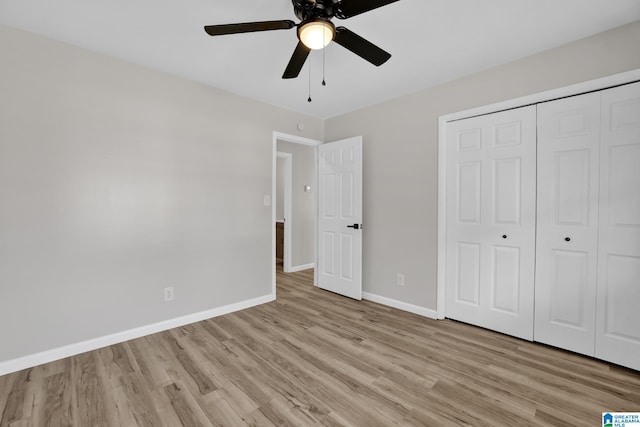 unfurnished bedroom featuring light wood-type flooring, ceiling fan, baseboards, and a closet