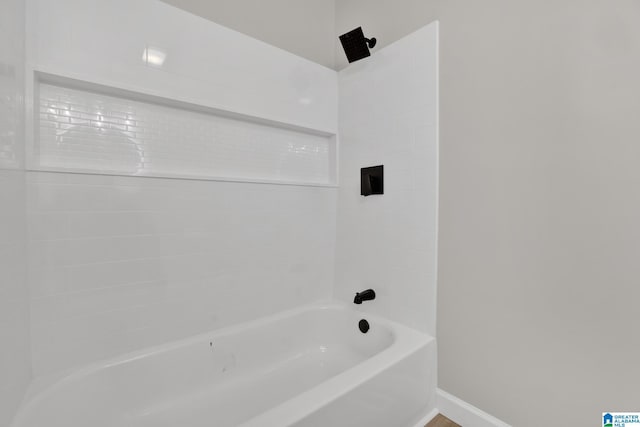 full bathroom with bathing tub / shower combination and baseboards