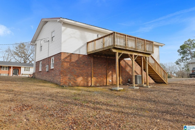 rear view of house featuring central AC, brick siding, stairway, and a wooden deck