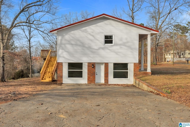 view of front facade with brick siding and stairway