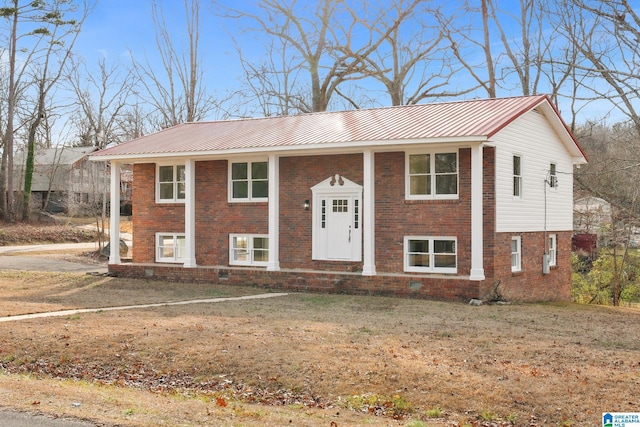 split foyer home with brick siding and metal roof