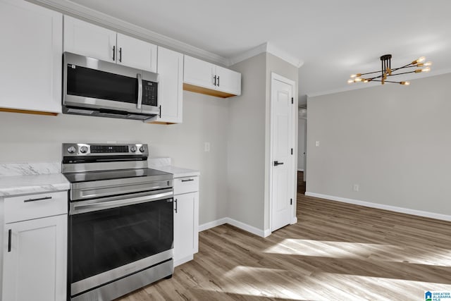 kitchen with a chandelier, light wood-style flooring, stainless steel appliances, white cabinetry, and baseboards