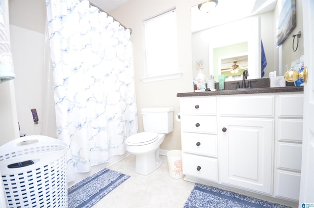 bathroom featuring toilet, a shower with curtain, ceiling fan, tile patterned floors, and vanity