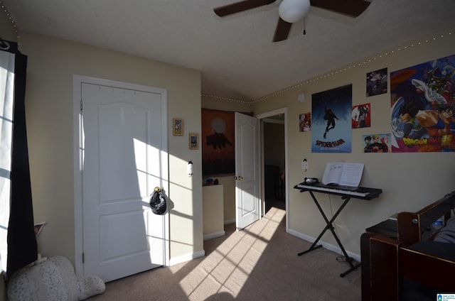 carpeted entrance foyer featuring a ceiling fan and baseboards